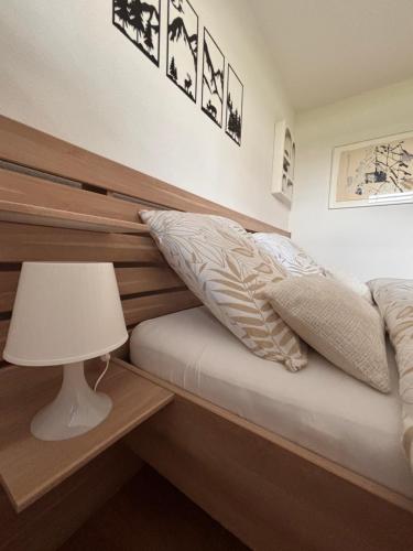a bedroom with a bed with a headboard and a lamp at Chez Baron in Hauterive