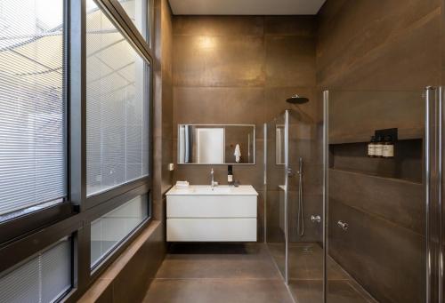 a bathroom with a sink and a shower and a mirror at master Shenkin in Tel Aviv