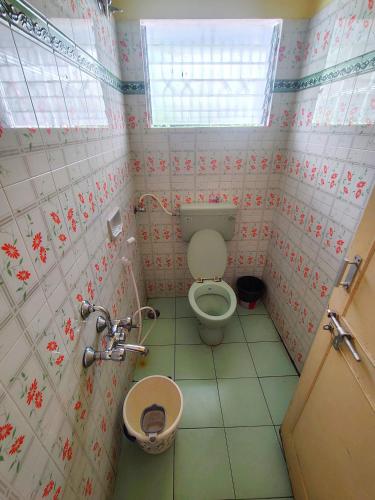 a small bathroom with a toilet and a sink at AKS Cottage in Yercaud