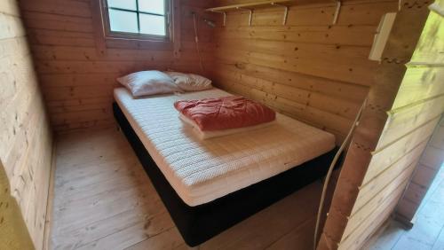 a room with two beds in a wooden cabin at Hjemstavnsgårdens Camping & Cottages in Glamsbjerg