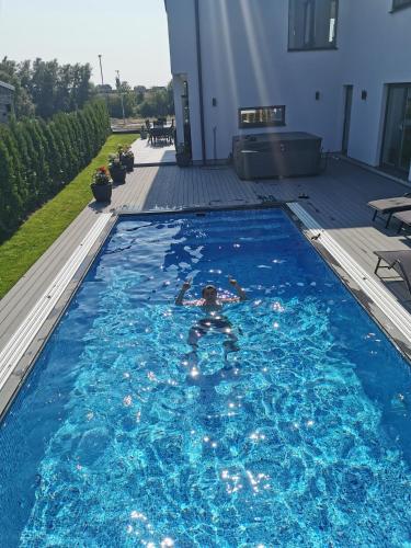 a person swimming in a swimming pool at Villa med pool in Bara