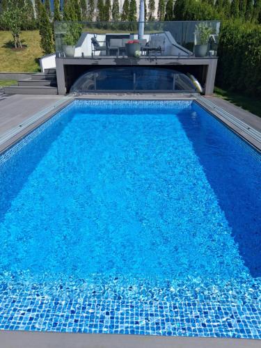 a swimming pool with blue water in a yard at Villa med pool in Bara