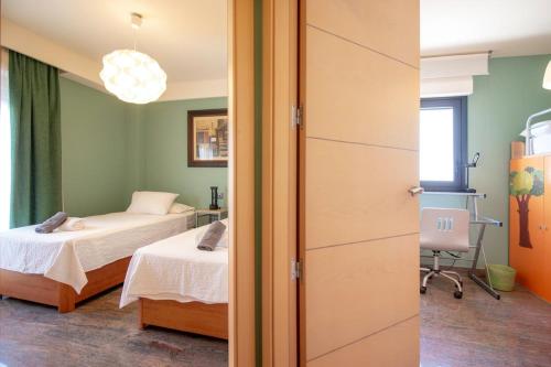 a bedroom with two beds and a room with a window at Plaza España - Nerja centro in Nerja