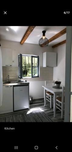 a kitchen with a white table and a white table and a sink at Sabina Olive bungalow in Ulcinj