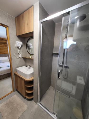a bathroom with a shower and a sink at PARADISO pool&house in Prosek