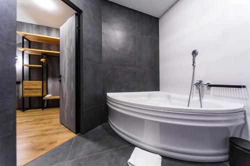a bathroom with a large white tub in a room at Rado Hotel Spa in Khmilnyk