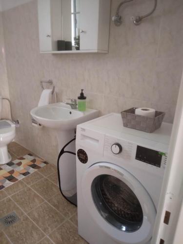 ein Badezimmer mit Waschmaschine und Waschbecken in der Unterkunft RIVER SIDE HOUSE in Potámion