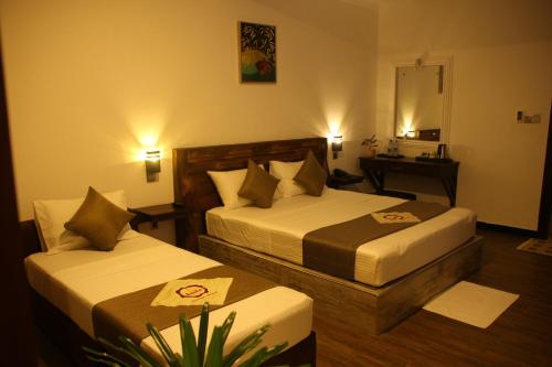 a hotel room with two beds and a desk at Sasha Transit Hotel in Katunayake