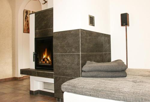 a bedroom with a fireplace and a bed with a blanket at Gartenapartment Malea in Schlitters