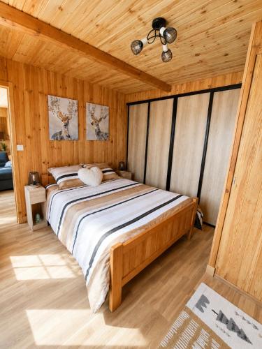 a bedroom with a large bed in a wooden room at Le cocon beuillois in Beuil
