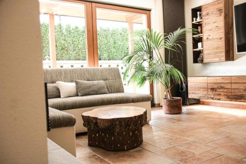 a living room with a couch and a tree stump coffee table at Gartenapartment Malea in Schlitters