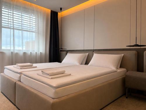 a bedroom with a large bed with two pillows on it at Wabi Hotel - Beauty & Dental Center in Sopron