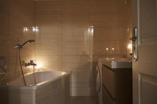 a bathroom with a bath tub and a sink at K&aacute;rolyi Garden | hostAID in Budapest