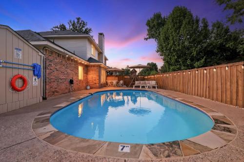 a swimming pool in a backyard with a fence at French-Style 5-BD w/ Pool, Playground, Cinema in Lewisville