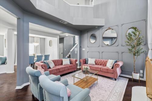 a living room with pink couches and blue chairs at French-Style 5-BD w/ Pool, Playground, Cinema in Lewisville