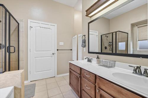 a bathroom with a sink and a large mirror at Spacious 5-BD 3-BA Forest View Getaway Sleeps 13 in Dallas