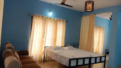 a bedroom with a bed and curtains and a couch at Yardlin Hotel in Perunkalattu