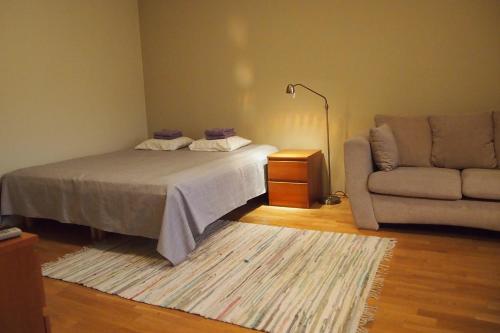 1 dormitorio con cama, sofá y alfombra en Haapsalu Old Town Apartment, en Haapsalu