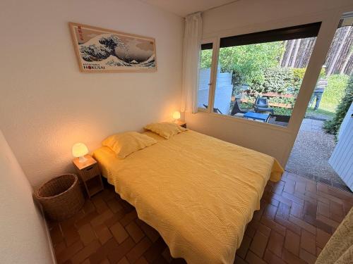 a bedroom with a bed and a large window at Le cottage landais in Lit-et-Mixe