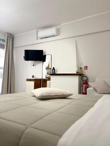 a white bedroom with a bed and a television at B&B Sibi in Chieti