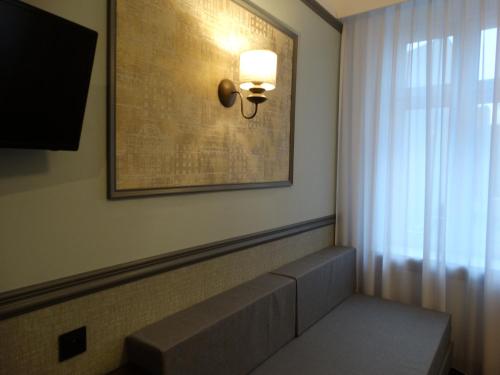a room with a bench and a picture on the wall at W Starej Kamienicy in Gniezno