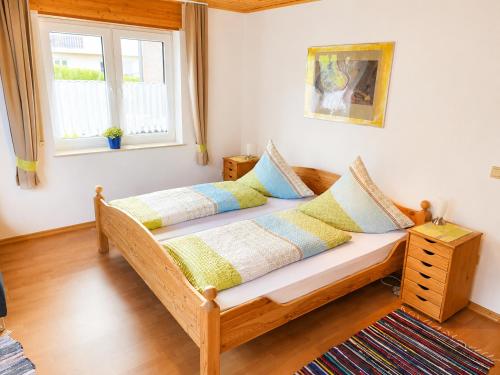 a bedroom with a wooden bed with pillows on it at Käthe's Gästezimmer in Reimerath