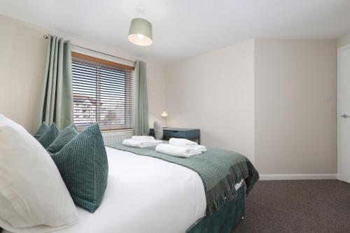 a bedroom with a large white bed and a window at Sea Point - 2 bed apartment in Saltcoats