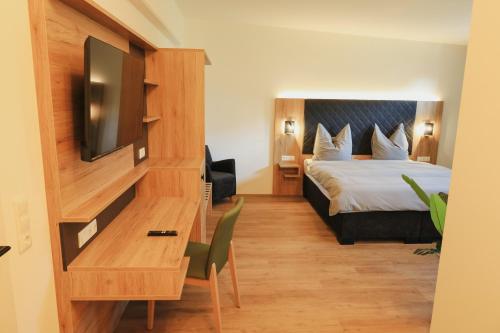 a hotel room with a bed and a television at A&E Hotel Friedrichshöhe in Braunschweig