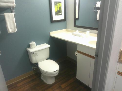 a bathroom with a white toilet and a sink at HomeTowne Studios by Red Roof Chantilly in Chantilly