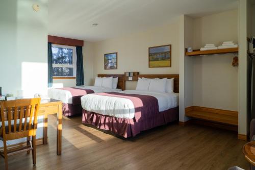 a hotel room with two beds and a table at Dutch Inn in Cornwall