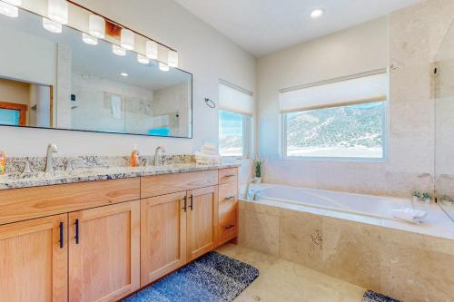 a bathroom with a tub and a large mirror at Beach Front Haven in Laketown