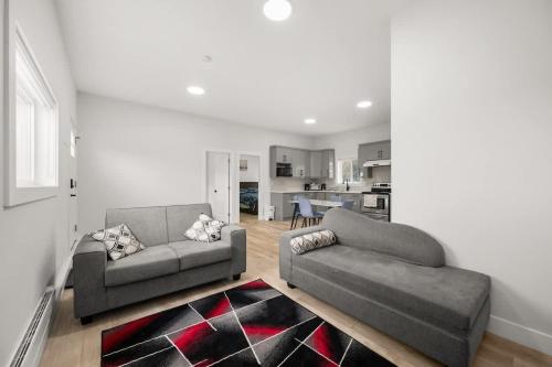 a living room with two couches and a kitchen at Private Farm Escape with Modern Comforts in Abbotsford