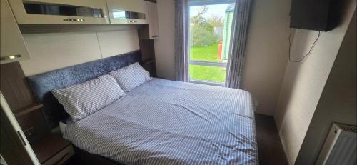 a small bedroom with a bed and a window at LJ Holiday Let in Middleton