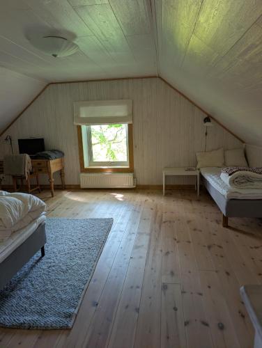 a attic room with two beds and a window at Villa Valdemar in Hammenhög