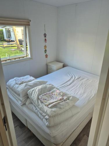 a bed in a room with a window at De vijverhut in Schagen