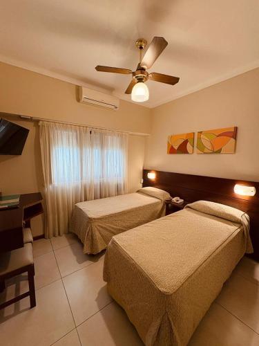 a hotel room with two beds and a ceiling fan at Hotel Selent in Mar del Plata