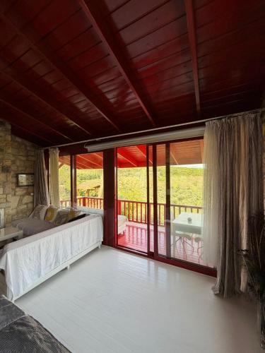 a bedroom with a bed and a balcony with sliding glass doors at Casa del Olivia in Seferihisar