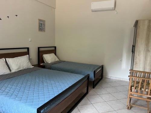 a bedroom with two beds and a fan at Casa Koutrea in Kastanéa