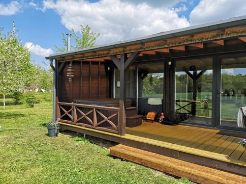 a pavilion with a wooden deck in a field at Medsukys - Namukai Dviem in Griniūnai
