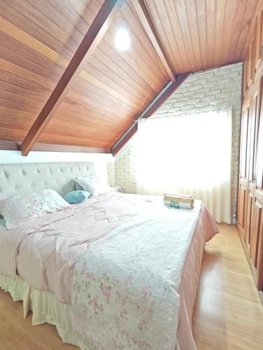 a bedroom with a large bed with a wooden ceiling at Chalé Deruci in Nova Friburgo