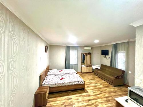 a bedroom with a bed and a couch in it at Ruslan Hotel 1 in Poti