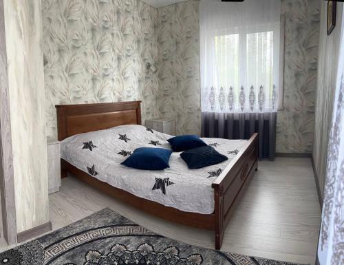 a bedroom with a large bed with blue pillows at Lake Relax in Chernihiv