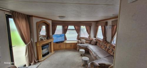 a living room with a couch and a flat screen tv at No 21 The Tummel in Forfar