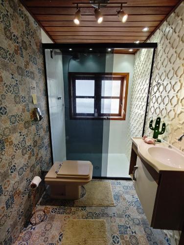 a bathroom with a toilet and a sink and a shower at Chalé Deruci in Nova Friburgo