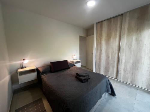 a bedroom with a bed with two night stands and two lamps at Andes Nomad Mendoza in Godoy Cruz
