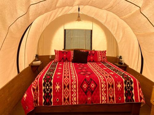 a bedroom with a red bed in an arched room at Broken Spur Inn & Steakhouse in Torrey