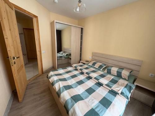 a bedroom with a bed with a checkered blanket at Bakuriani Valley 10 in Bakuriani