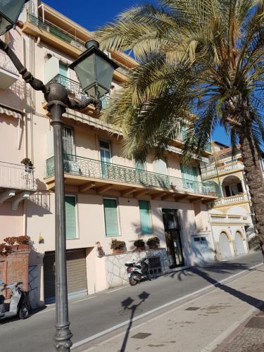 a street light in front of a building with a palm tree at Appartamento Trento Trieste in Sanremo
