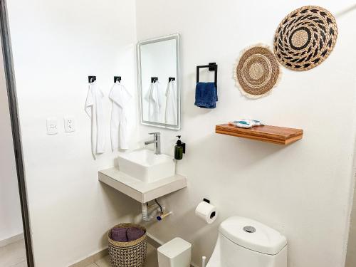 a white bathroom with a sink and a toilet at TAYGA STUDIOS Cancun in Cancún