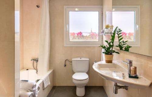 a bathroom with a toilet and a sink and a tub at Hotel la Palmera & Spa in Lloret de Mar
